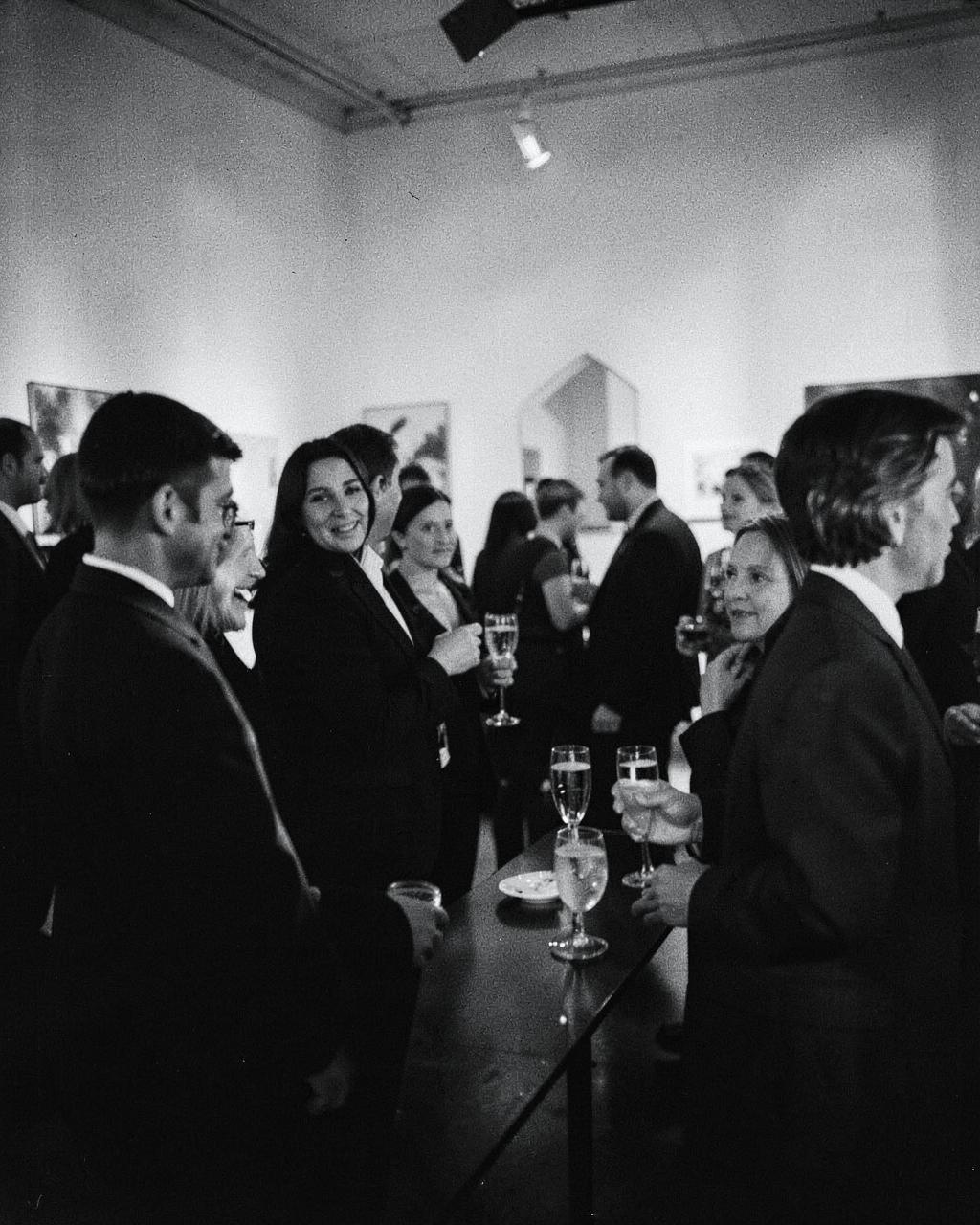 Invitados conversando en la inauguración de una galería